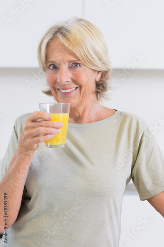 Photo: Smiling woman drinking orange juice Smiling woman drinking orange juice