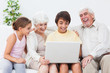 Grandparents and grandchildren using laptop