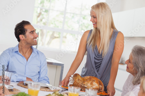 Photo: Happy wife bringing turkey to the table Happy wife bringing turkey to the table