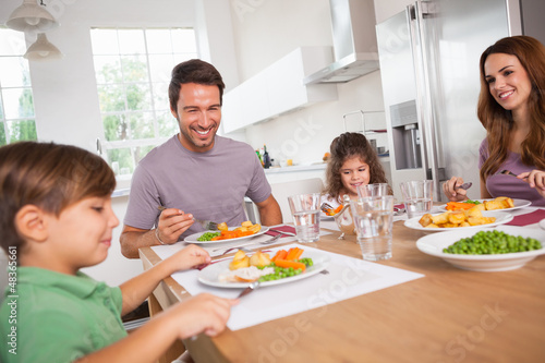 Photo: Family smiling around a good meal Family smiling around a good meal