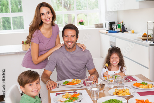 Photo: Family smiling at the dinner table Family smiling at the dinner table