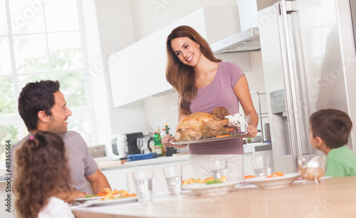 Photo: Mother bringing roast turkey to table Mother bringing roast turkey to table