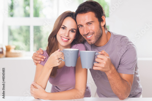 Photo: Couple looking at the camera with a coffee Couple looking at the camera with a coffee