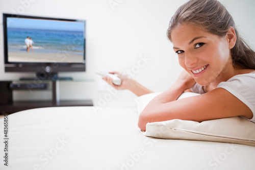 Photo: Smiling woman watching television Smiling woman watching television