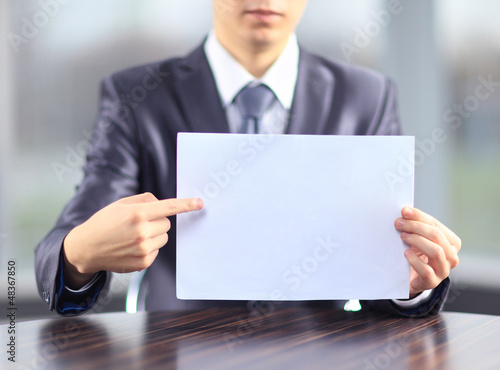 Photo: A businessman with a poster to advertise. A businessman with a poster to advertise.