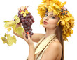 beautiful young woman with yellow autumn wreath and grapes,