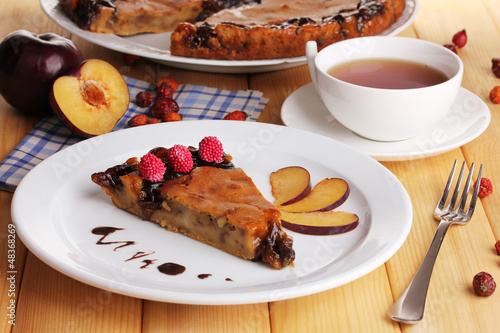 Photo: Tasty pie on plate on wooden table Tasty pie on plate on wooden table