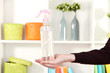 Sprayed air freshener in hand on white shelves background