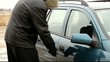 Robber with a crowbar near car