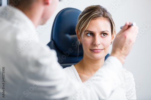 Photo: Optometry concept - pretty young woman having her eyes examined Optometry concept - pretty young woman having her eyes examined