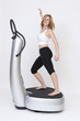 Junge sportliche Frau tanzt Zumba auf einer Powerplate
