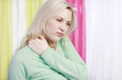 Hübsche blonde Frau mit Nackenschmerzen