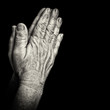 Photo: Old wrinkled hands praying isolated on black Old wrinkled hands praying isolated on black