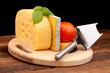 Various types of cheese on wooden table and black background