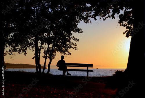 Photo: Man Sitting On Bench By A Beach During A Beautiful Sunset Man Sitting On Bench By A Beach During A Beautiful Sunset