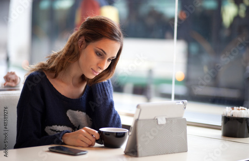 Photo: Candid image of a young woman using tablet computer Candid image of a young woman using tablet computer