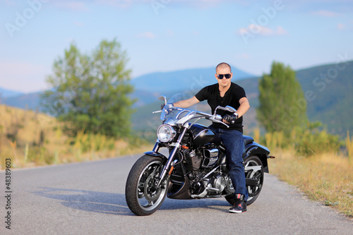 Photo: Man posing on a custom made motorcycle Man posing on a custom made motorcycle