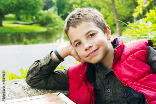 Photo: Cute teenage boy smiling against green background Cute teenage boy smiling against green background