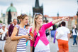Two female tourists walking along the Charles Bridge