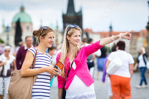 Photo: Two female tourists walking along the Charles Bridge Two female tourists walking along the Charles Bridge