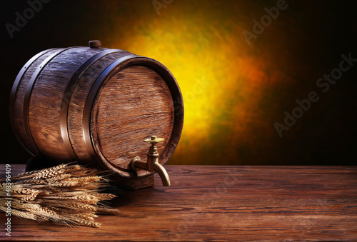 Photo: Old oak barrel on a wooden table. Old oak barrel on a wooden table.