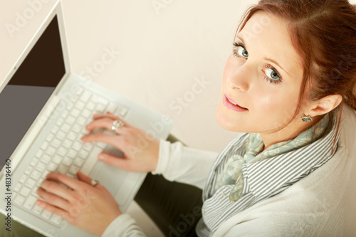 Photo: Portrait of a lovely young lady using a laptop. Portrait of a lovely young lady using a laptop.