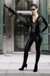 Sexy woman holding gun wearing a black leather dress