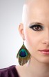 Half face studio portrait of hairless woman