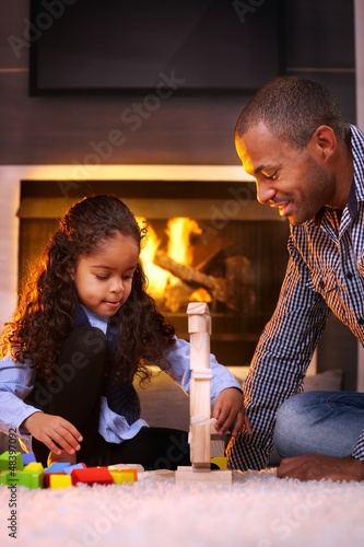 Photo: Ethnic father and daughter playing together Ethnic father and daughter playing together