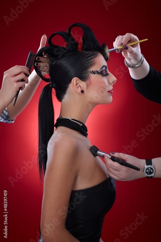 Photo: Makeup artists working on devil woman Makeup artists working on devil woman