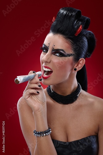 Photo: Wicked woman smoking banknotes Wicked woman smoking banknotes