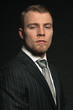 Fashion man wearing grey suit. Studio shot against black.