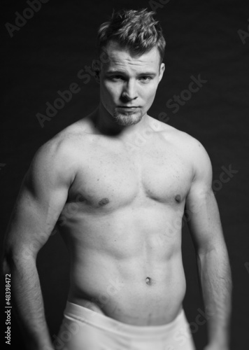 Photo: Muscled fitness man. Black and white studio shot. Muscled fitness man. Black and white studio shot.