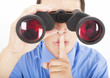 man looks through binoculars with silent gesture