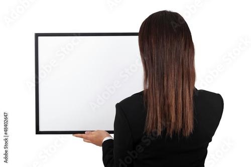 Photo: Woman back at the camera holding a frame. Woman back at the camera holding a frame.