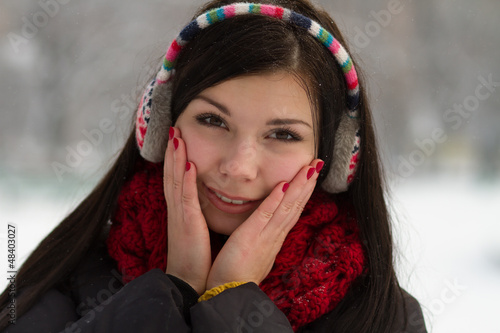 Photo: Girl in earplugs outdoors in winter Girl in earplugs outdoors in winter