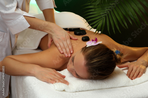 Photo: beautiful young woman in spa salon getting massage with spa beautiful young woman in spa salon getting massage with spa