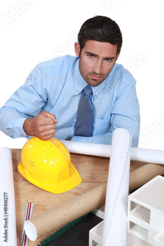 Photo: Architect with his fist on a hard hat Architect with his fist on a hard hat