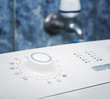 Photo: Washing machine with faucet in background Washing machine with faucet in background