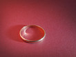 gold ring on red paper background abstract