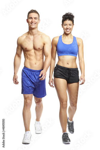 Photo: Young man and woman walking in sports outfits Young man and woman walking in sports outfits
