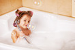 Little girl  in curlers in the bathtub