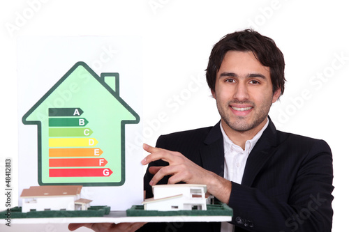 Photo: Architect holding model house and energy rating card Architect holding model house and energy rating card