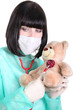 Doctor listening to the heartbeat of a teddy bear