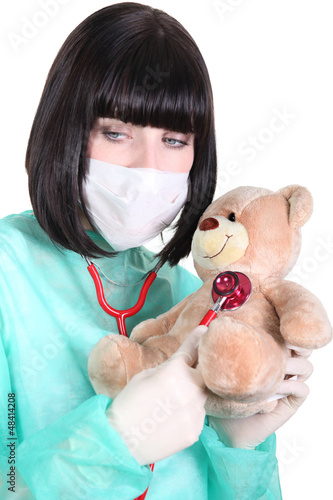 Photo: Doctor listening to the heartbeat of a teddy bear Doctor listening to the heartbeat of a teddy bear