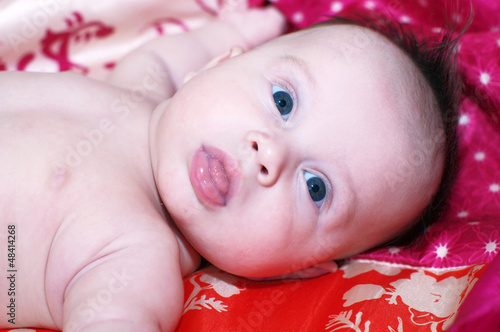 Photo: The baby lies on a red plaid (3 months) The baby lies on a red plaid (3 months)