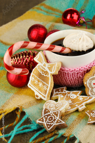 Photo: Cup of coffee with Christmas sweetness on plaid close-up Cup of coffee with Christmas sweetness on plaid close-up