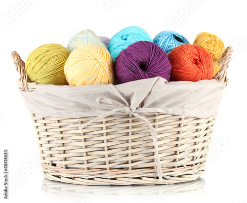 Photo: Colorful yarn balls in wicker basket isolated on white Colorful yarn balls in wicker basket isolated on white