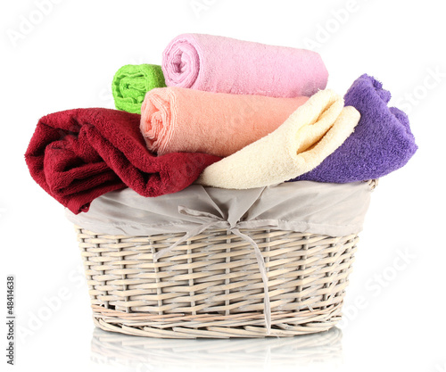 Photo: Colorful towels in basket isolated on white Colorful towels in basket isolated on white
