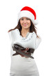 Woman showing ice skates in christmas santa hat smiling